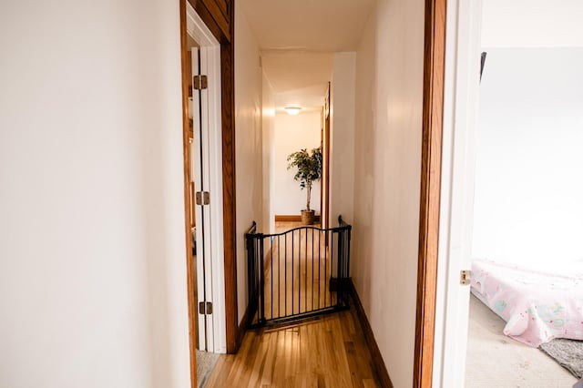 hallway with baseboards and wood finished floors