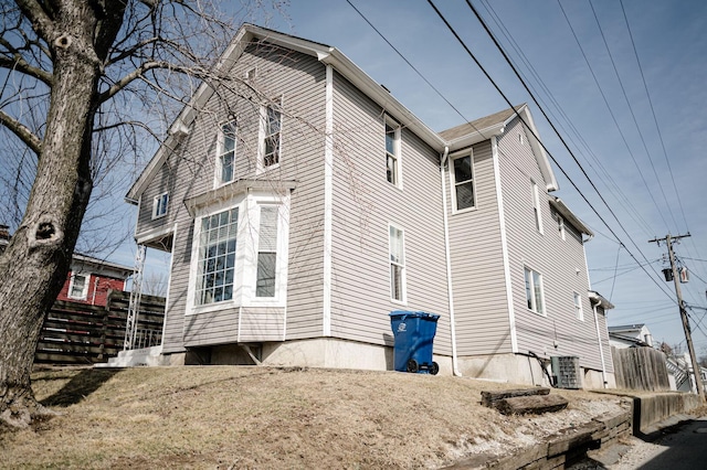 view of home's exterior featuring central air condition unit and fence