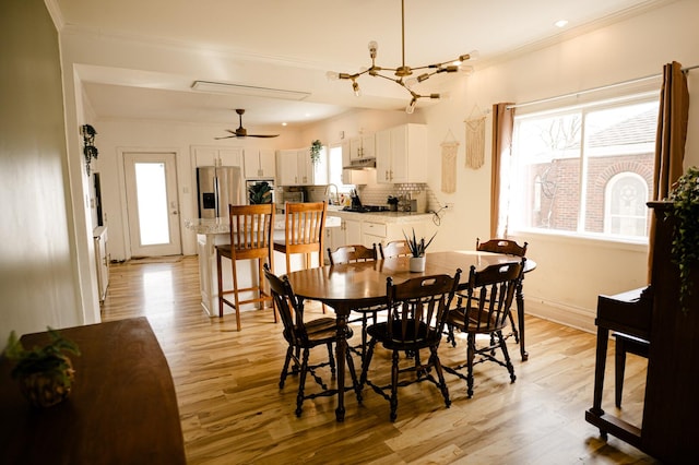 dining area with a wealth of natural light, light wood-style flooring, and ornamental molding