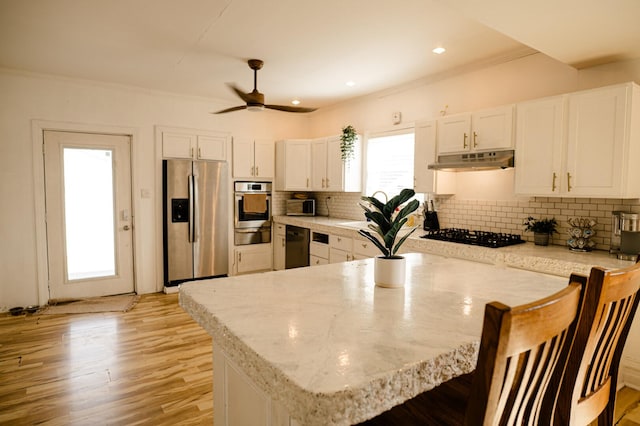 kitchen with black appliances, under cabinet range hood, backsplash, white cabinetry, and light wood-style floors