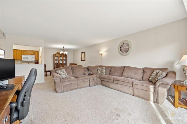 living area featuring a notable chandelier, light colored carpet, and visible vents