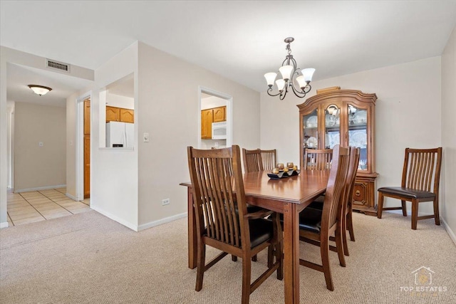 dining room with light carpet, visible vents, baseboards, and an inviting chandelier