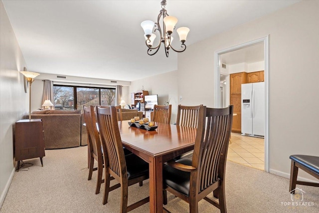 dining area featuring light tile patterned floors, baseboards, light carpet, and a notable chandelier