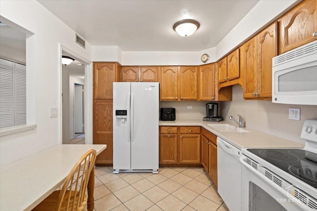 kitchen with visible vents, light countertops, light tile patterned floors, white appliances, and a sink