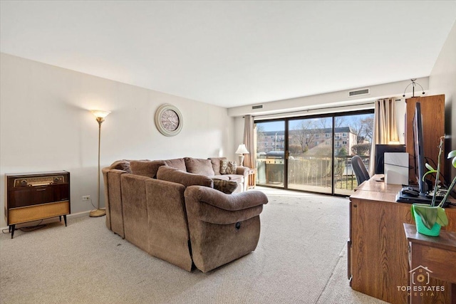 living area featuring visible vents, baseboards, and light colored carpet