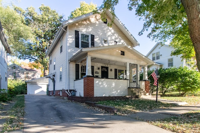 view of front of house with a porch, an outbuilding, and a detached garage