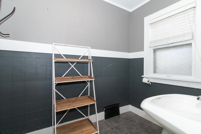 bathroom featuring tile patterned floors, tile walls, and wainscoting