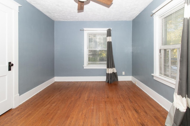 unfurnished room with ceiling fan, baseboards, a textured ceiling, and wood finished floors