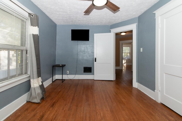 spare room with wood finished floors, baseboards, visible vents, ceiling fan, and a textured ceiling