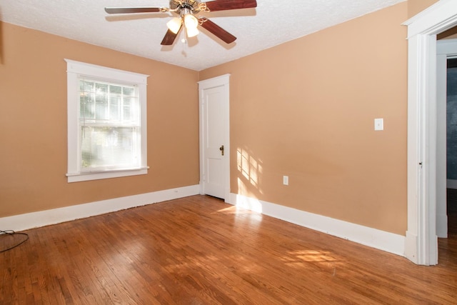 spare room featuring baseboards, a textured ceiling, wood finished floors, and a ceiling fan