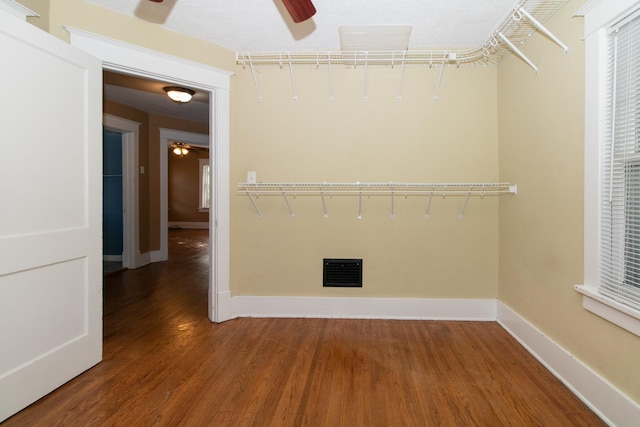 unfurnished room featuring visible vents, baseboards, ceiling fan, and wood finished floors