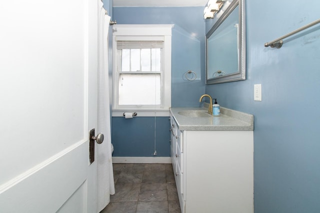 full bath with vanity and baseboards