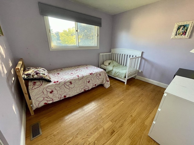 bedroom with visible vents, baseboards, and light wood-style floors