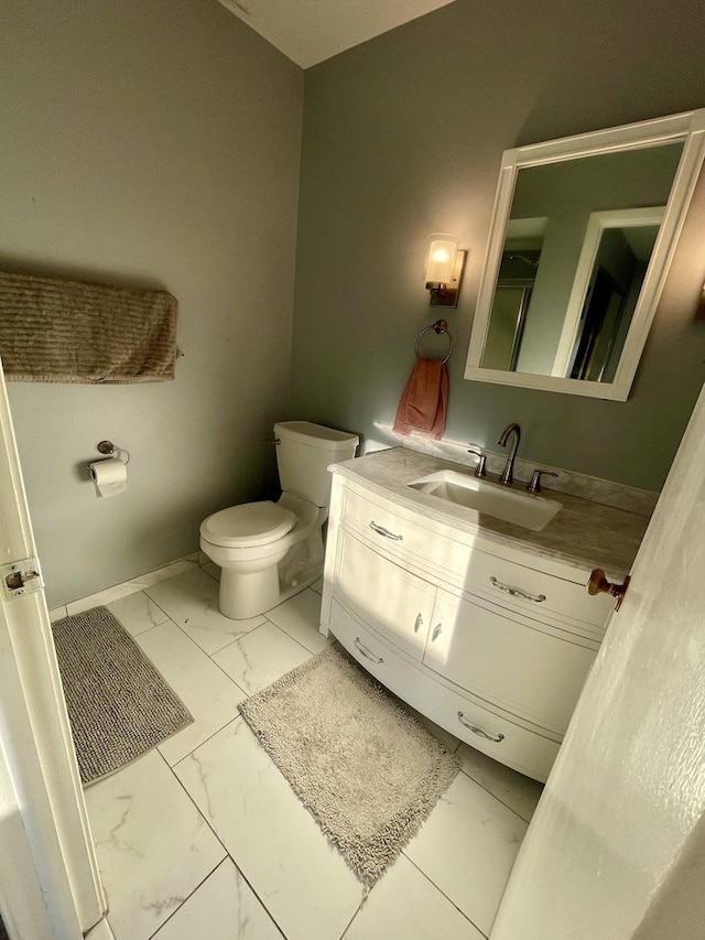 bathroom featuring marble finish floor, toilet, vanity, and baseboards