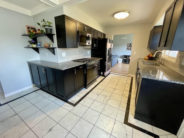 kitchen featuring dark stone counters, tasteful backsplash, appliances with stainless steel finishes, and a sink