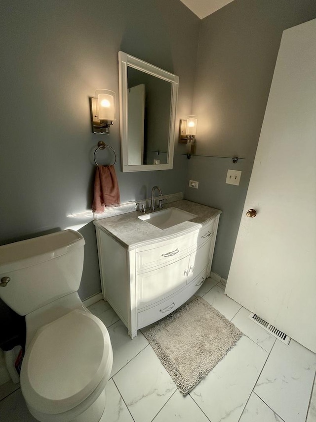 bathroom featuring vanity, visible vents, baseboards, toilet, and marble finish floor