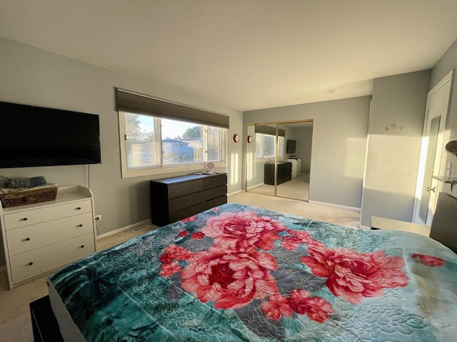 bedroom featuring light colored carpet, baseboards, and a closet