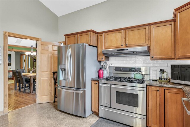 kitchen with brown cabinetry, backsplash, appliances with stainless steel finishes, and under cabinet range hood