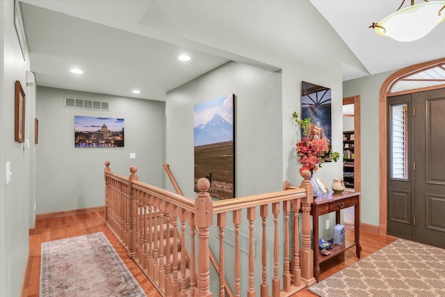 foyer entrance featuring visible vents, baseboards, lofted ceiling, recessed lighting, and wood finished floors