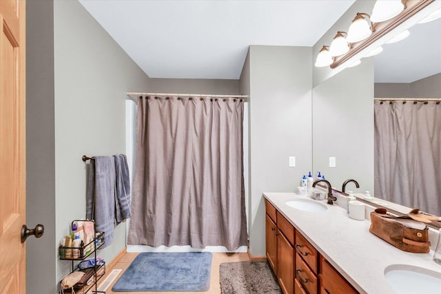 full bathroom featuring curtained shower, double vanity, and a sink