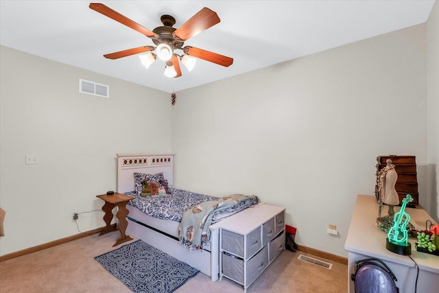 bedroom with visible vents, light colored carpet, baseboards, and ceiling fan