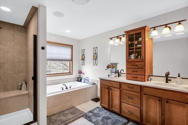 bathroom with tile patterned floors, a shower stall, a garden tub, and a sink