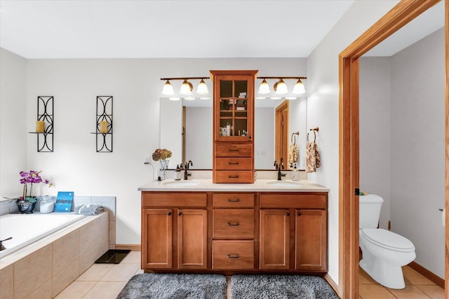 bathroom with tile patterned flooring, a garden tub, and a sink