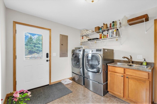 laundry room featuring baseboards, washing machine and dryer, electric panel, light tile patterned floors, and a sink