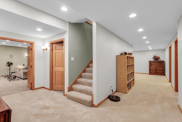 interior space featuring recessed lighting, baseboards, light colored carpet, and stairs