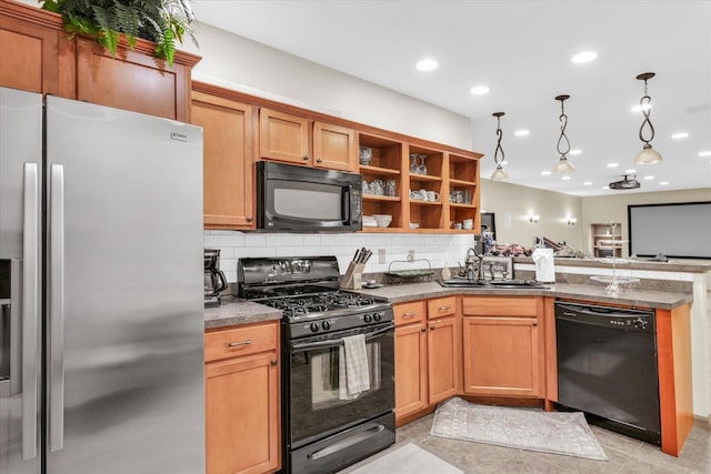 kitchen featuring black appliances, a peninsula, tasteful backsplash, and a sink