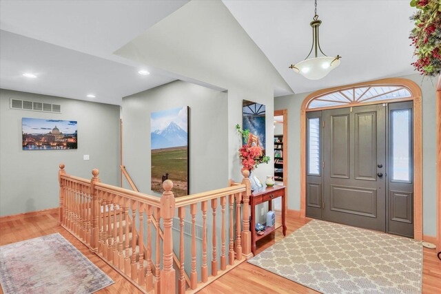 entryway with visible vents, wood finished floors, recessed lighting, baseboards, and lofted ceiling