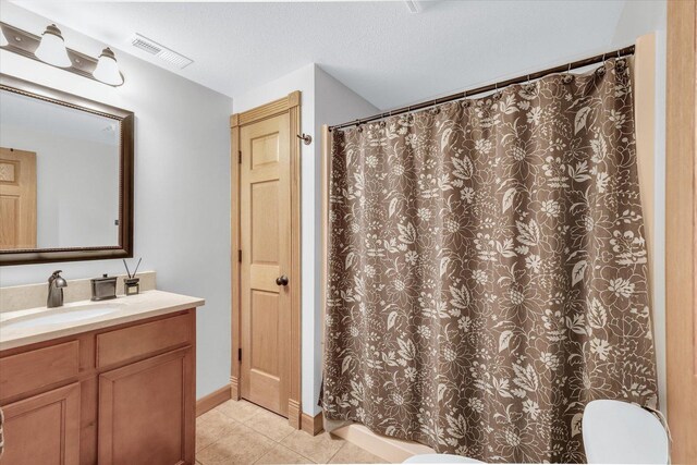 bathroom featuring vanity, visible vents, tile patterned flooring, a textured ceiling, and toilet