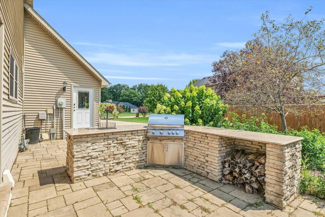 view of patio featuring area for grilling and fence