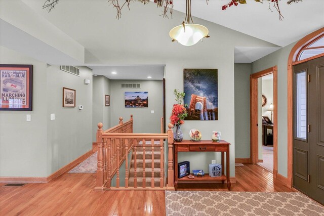 foyer entrance featuring visible vents, baseboards, and wood finished floors