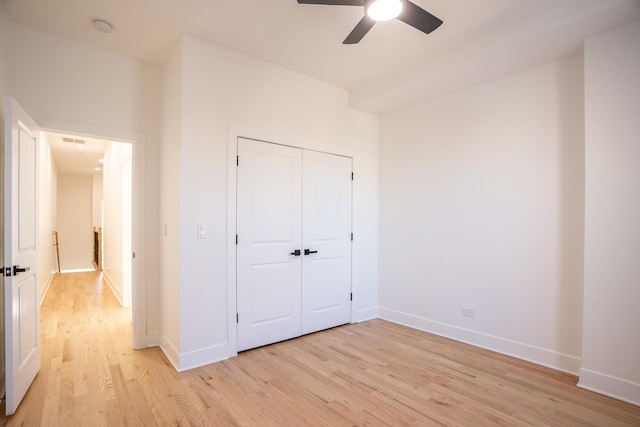 unfurnished bedroom with light wood-style flooring, visible vents, baseboards, and a closet
