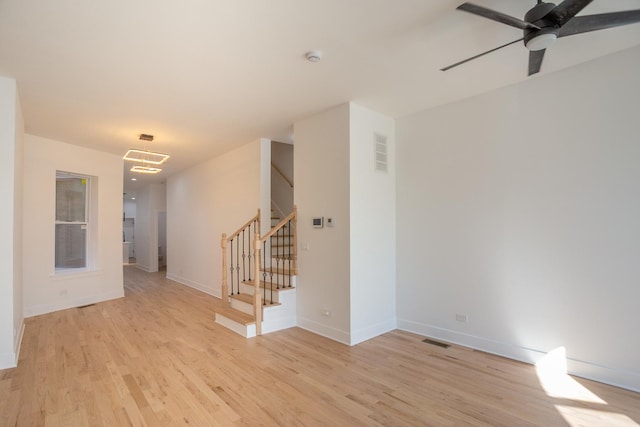 spare room with visible vents, light wood-style floors, and stairway