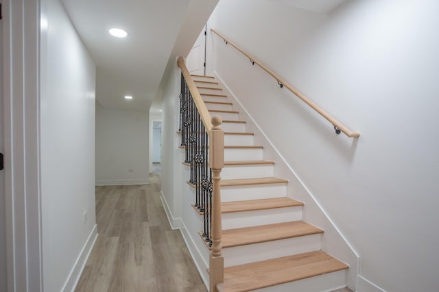 stairway featuring recessed lighting, baseboards, and wood finished floors