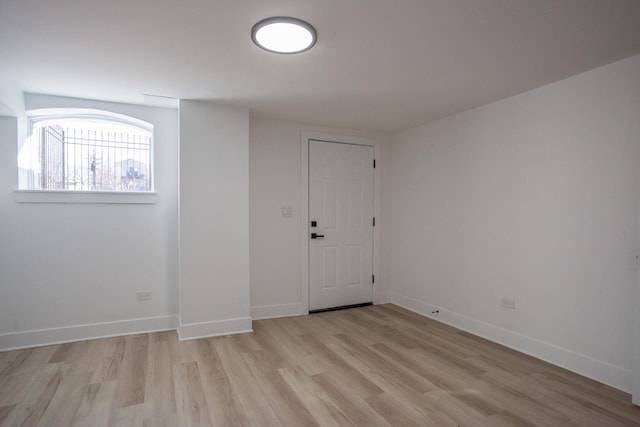 unfurnished room with baseboards and light wood finished floors