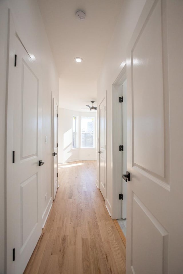 hallway featuring recessed lighting, baseboards, and light wood-style flooring