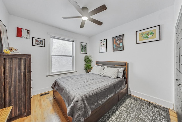 bedroom featuring visible vents, baseboards, light wood-style floors, and ceiling fan