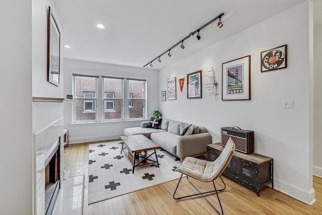 living area with recessed lighting, rail lighting, baseboards, and wood finished floors