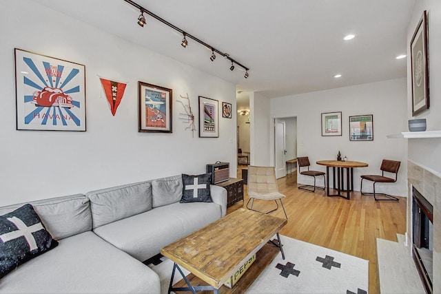 living area featuring recessed lighting, light wood finished floors, rail lighting, and a tile fireplace