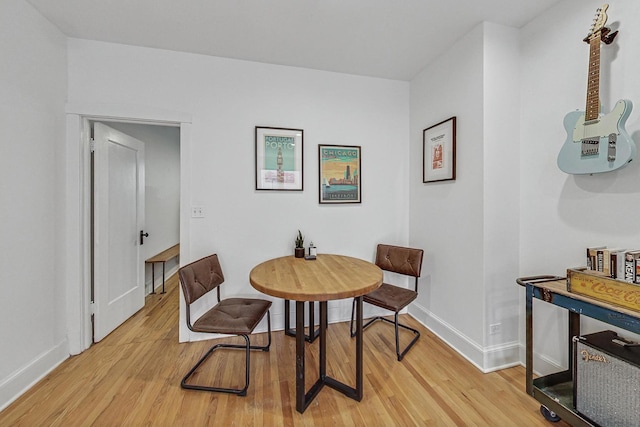 dining space featuring baseboards and light wood-type flooring