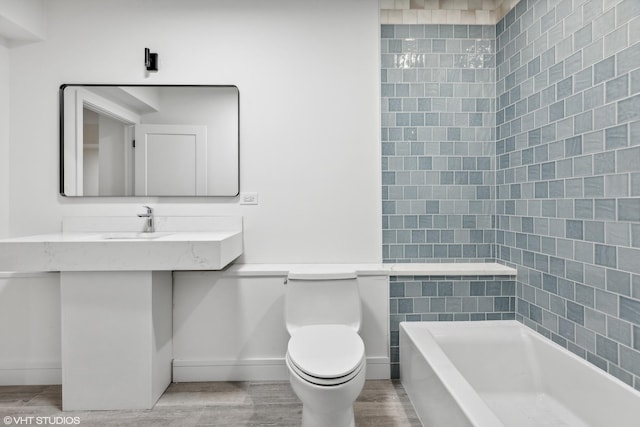 bathroom with a sink, baseboards, toilet, and wood finished floors