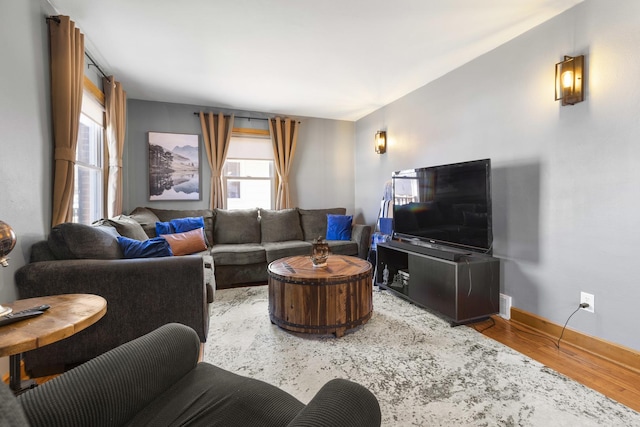 living area with baseboards and wood finished floors