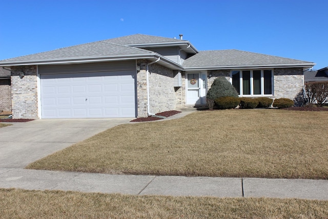 view of front of house featuring driveway, a front lawn, roof with shingles, an attached garage, and brick siding