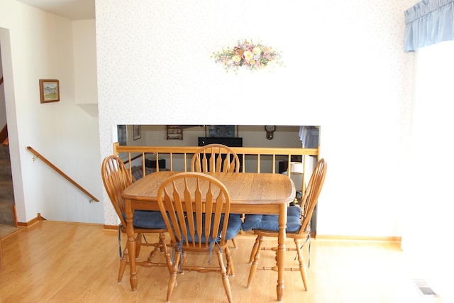 dining area featuring wood finished floors, visible vents, and baseboards