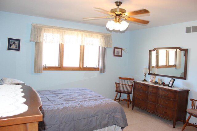 bedroom featuring a ceiling fan, light colored carpet, and visible vents