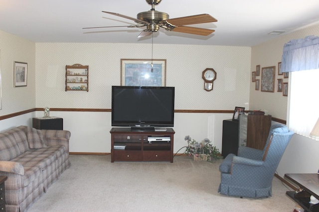 carpeted living area with baseboards, a ceiling fan, and wallpapered walls