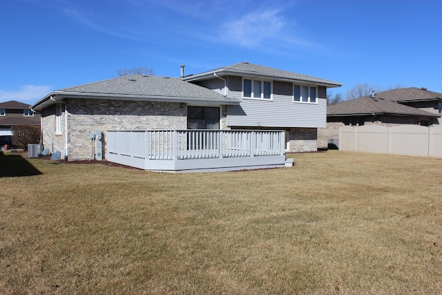 rear view of property with brick siding, central air condition unit, a lawn, and fence